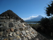 Stone model of Mount Fuji, with the mountain itself in the background