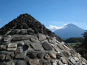 Stone model of Mount Fuji, with the mountain itself in the background