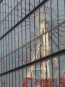 A ferris wheel is reflected by a glass building