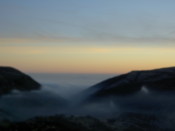 Hills poke out of the thick cloud