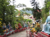 Colourful Buddhas on a path above the temple