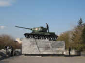 Man climbs on a tank in a park